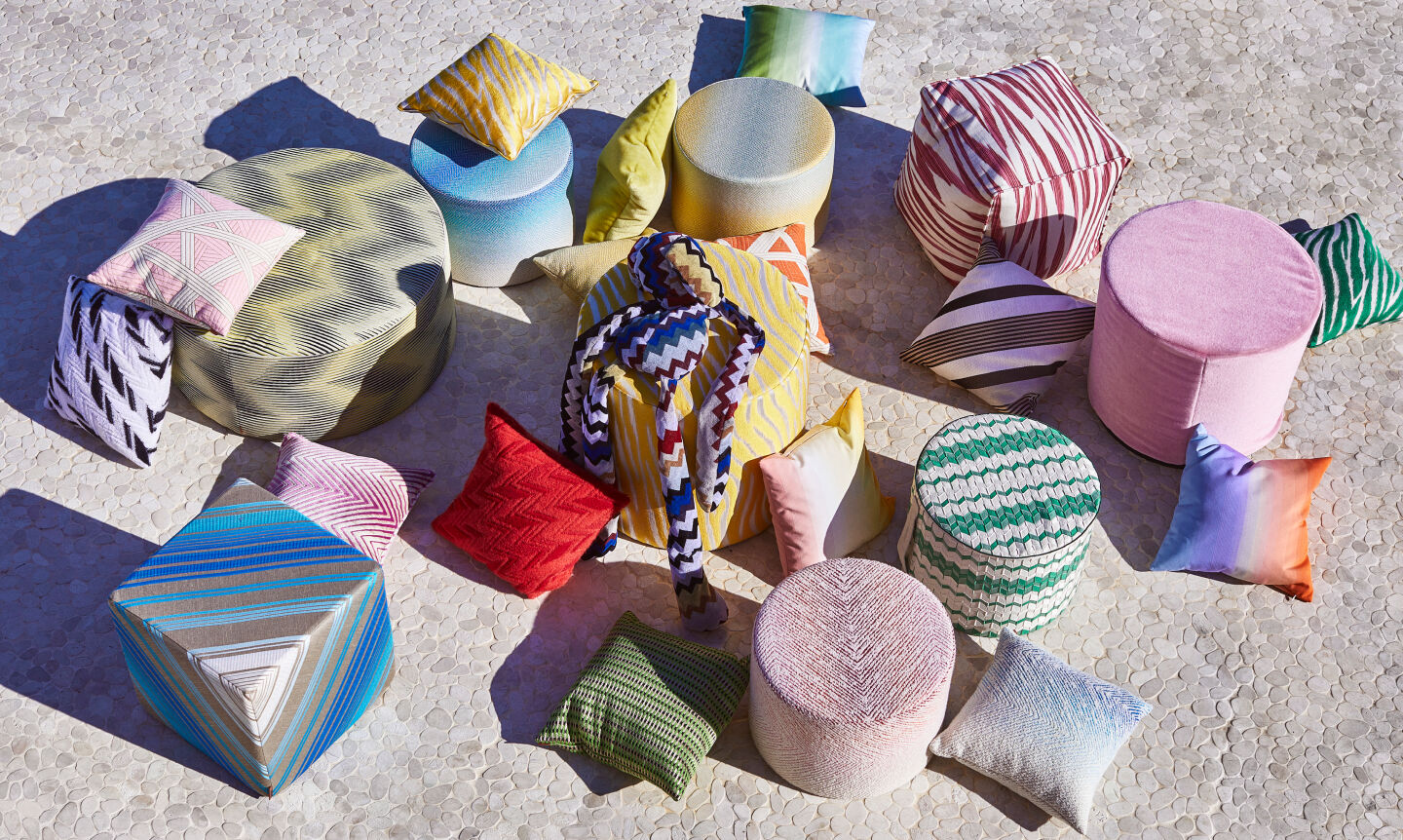 Multicoloured pouffs and pillows from the 2023 Home collection are placed all around
